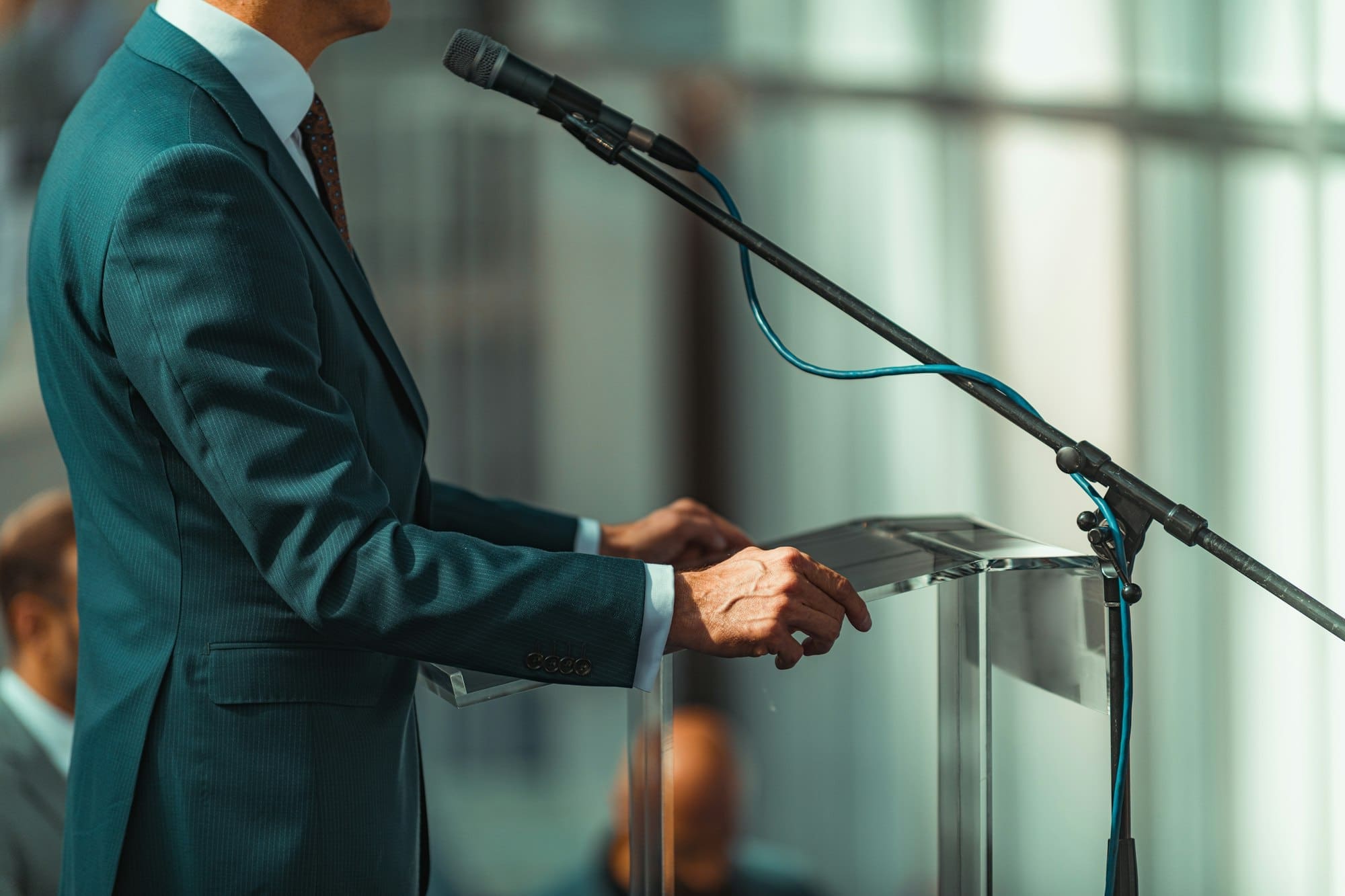 Male Speaker Standing In Front Of Microphones